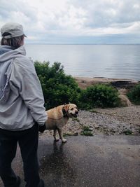 Man with dog standing in sea