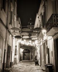 Empty alley amidst buildings at night