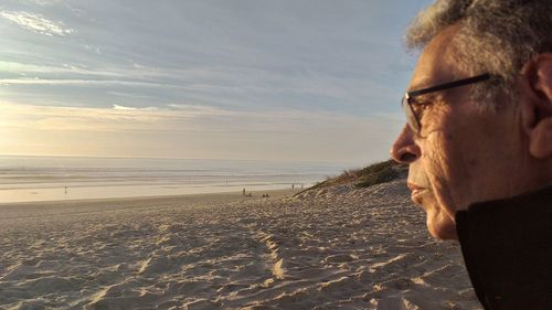 Man on shore at beach against sky