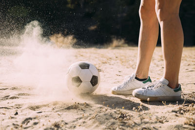 Low section of man playing soccer at night