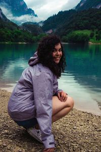 Young woman sitting at lakeshore