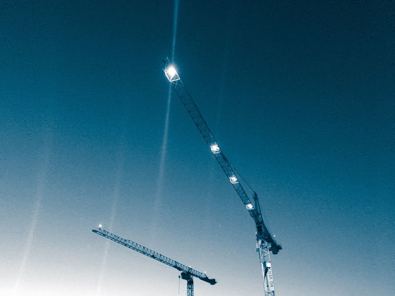 LOW ANGLE VIEW OF ILLUMINATED VAPOR TRAIL AGAINST CLEAR SKY