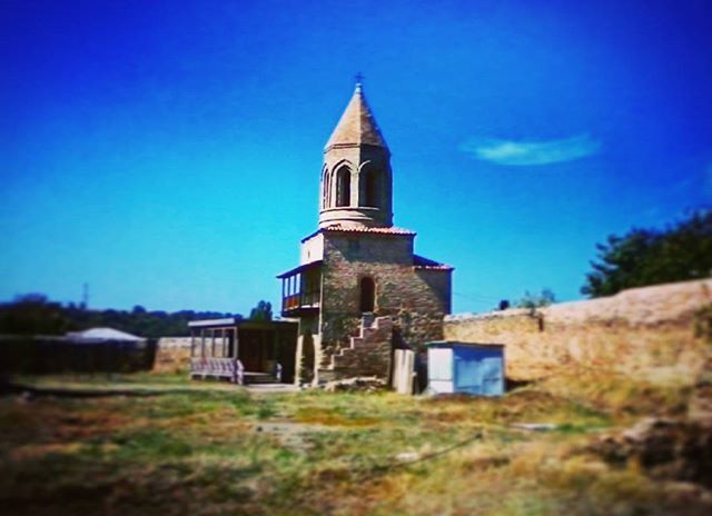 architecture, building exterior, built structure, blue, religion, place of worship, clear sky, church, spirituality, low angle view, sky, tower, history, copy space, day, outdoors, tree, no people