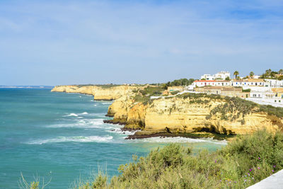 Scenic view of sea by buildings against sky