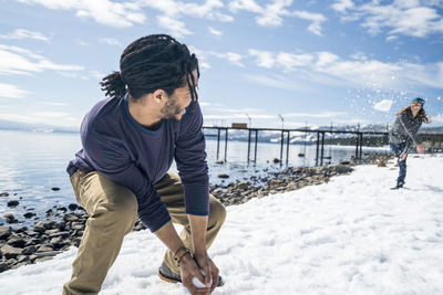 A man and woman have a snowball fight near a pier in south lake tahoe, ca