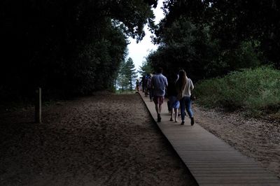 Rear view of people walking on road