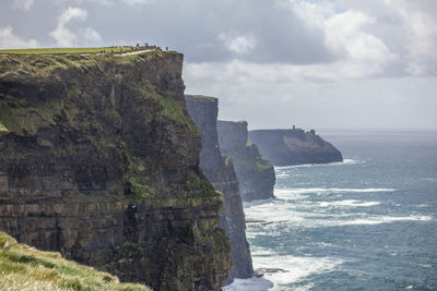 Rock formation by sea against sky