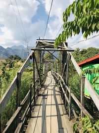 Footbridge on footpath against sky