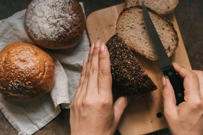 Close-up of hands cutting bread