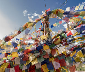 Low angle view of colorful umbrellas hanging against sky