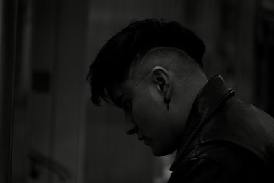 Side view of young man looking away at home