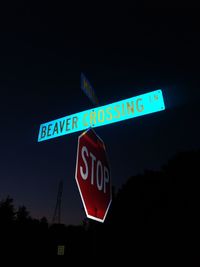 Low angle view of road sign against clear blue sky