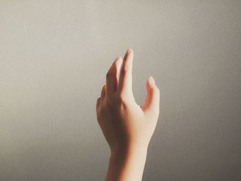 Close-up of hand against wall