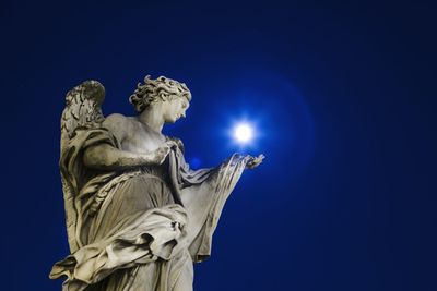 Low angle view of statue against blue sky