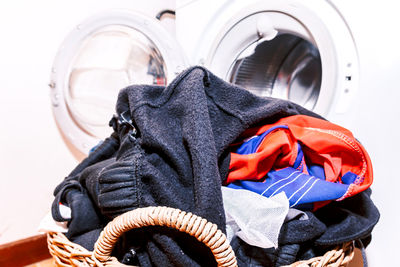 Close-up of basket with clothes by washing machine