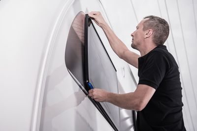 Low angle view of worker repairing motor home