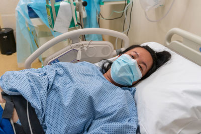 High angle view of woman lying on bed at hospital