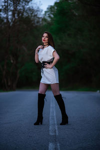 Full length portrait of woman standing on road