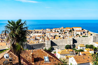 Houses by sea against blue sky