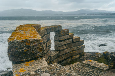 Close-up of groyne by sea against sky