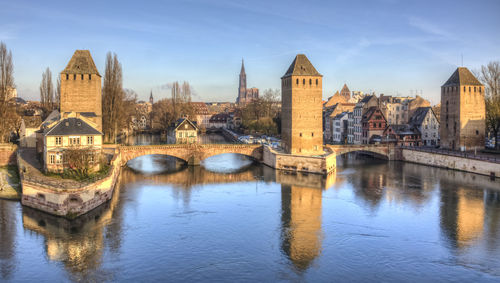 Arch bridge over river against buildings in city