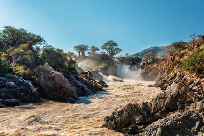 Scenic view of waterfall against clear sky