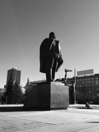 Man jumping in city against clear sky