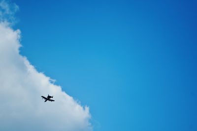 Low angle view of vapor trails against blue sky