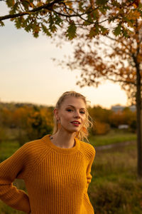 Portrait of a smiling young woman against trees