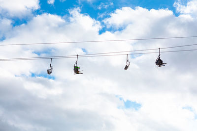 Skiers on the rope against sky . ski lift with people