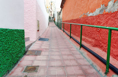 Empty walkway amidst buildings