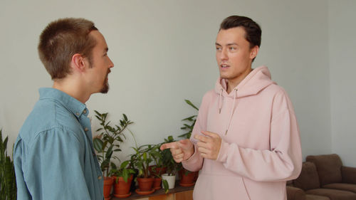 Portrait of couple standing against wall