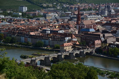 High angle view of townscape by river in city