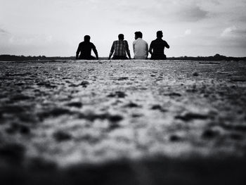 Silhouette of friends standing at sunset