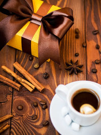 High angle view of coffee and gift on table
