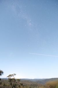 Scenic view of vapor trails against clear blue sky