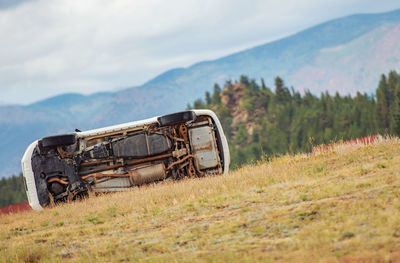 Abandoned truck on field against sky