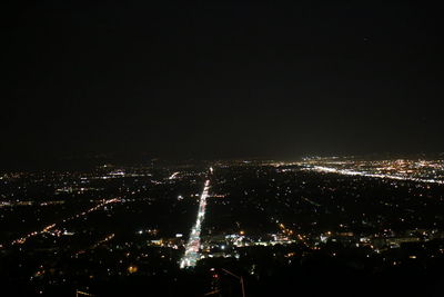 Aerial view of illuminated cityscape against sky at night