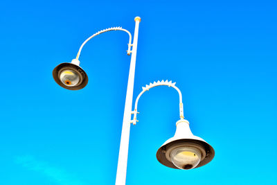 Low angle view of street light against blue sky