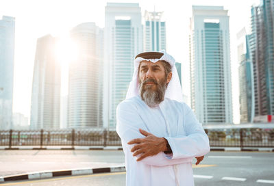 Mid adult man standing against buildings in city