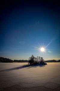 Scenic view of landscape against blue sky during winter