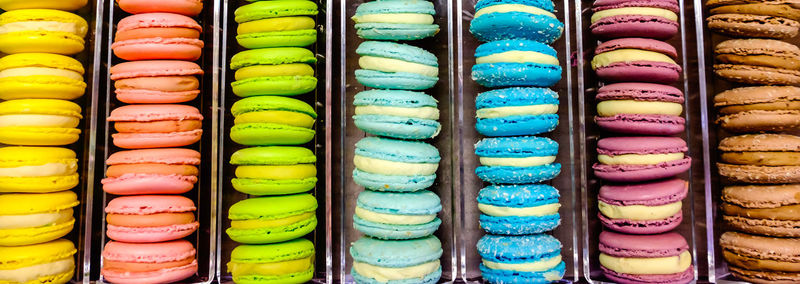 Panoramic shot of macaroons in container for sale at store