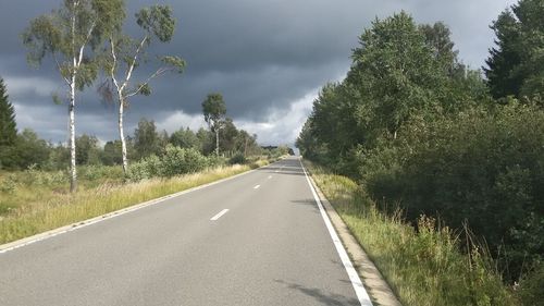 Road amidst trees against sky