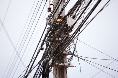 Low angle view of electricity pylon against sky