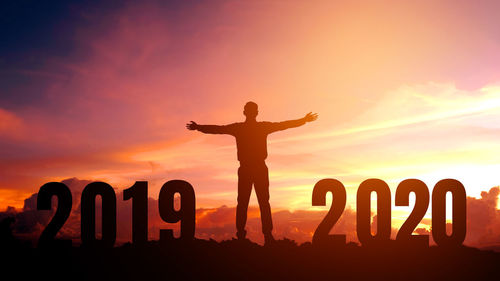 Silhouette man standing against orange sky