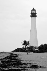 Lighthouse by sea against sky