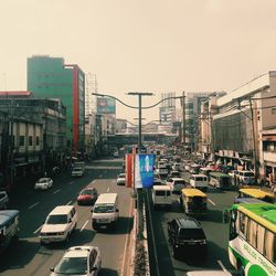Vehicles on road in city against clear sky