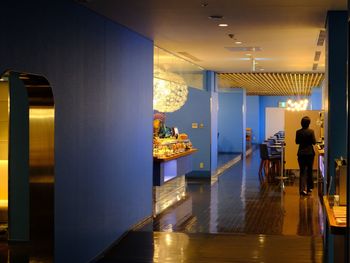 Rear view of people walking in illuminated building