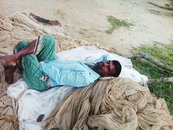 High angle portrait of young man lying on textile