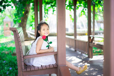 Portrait of smiling girl holding while sitting on seat